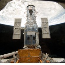 The Hubble Space Telescope stands tall in the cargo bay of the Space Shuttle Atlantis following its capture and lock-down in Earth orbit. Credit: NASA
