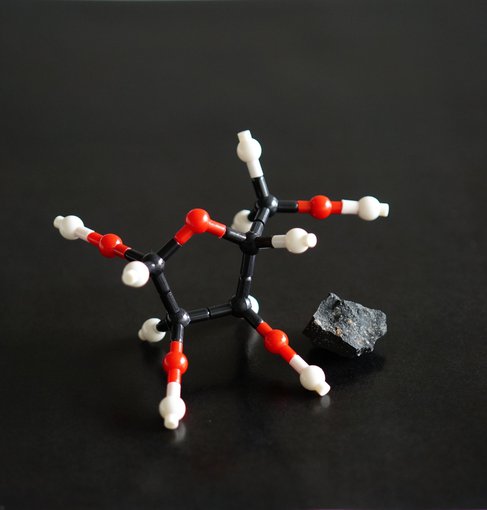 This is a model of the molecular structure of ribose and an image of the Murchison meteorite. Ribose and other sugars were found in this meteorite.