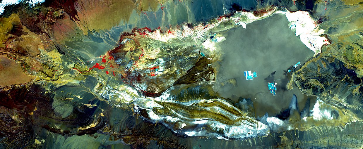 Landsat 7 image of Salar de Atacama from March 21, 2002. The Salt Pan is mostly a grey-green with some white and cyan. Bare ground and rock range from tan and brown to green and dark grey. Snow is white and vegetation is red.