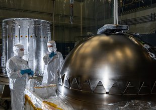 Engineers at NASA’s Goddard Space Flight Center in Greenbelt, Maryland, prepare for a propellant tank to be inserted into the cylinder in the background at left. The cylinder is one of two that make up Europa Clipper’s propulsion module.