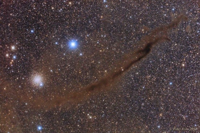 This snakelike gas cloud (center dark area) in the constellation Musca resembles a skinny filament. But it’s actually a flat sheet that extends about 20 light-years into space away from Earth, an analysis finds.