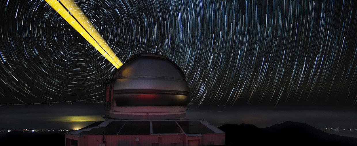 This image features the Gemini North telescope during laser guide star operations (LGS).
