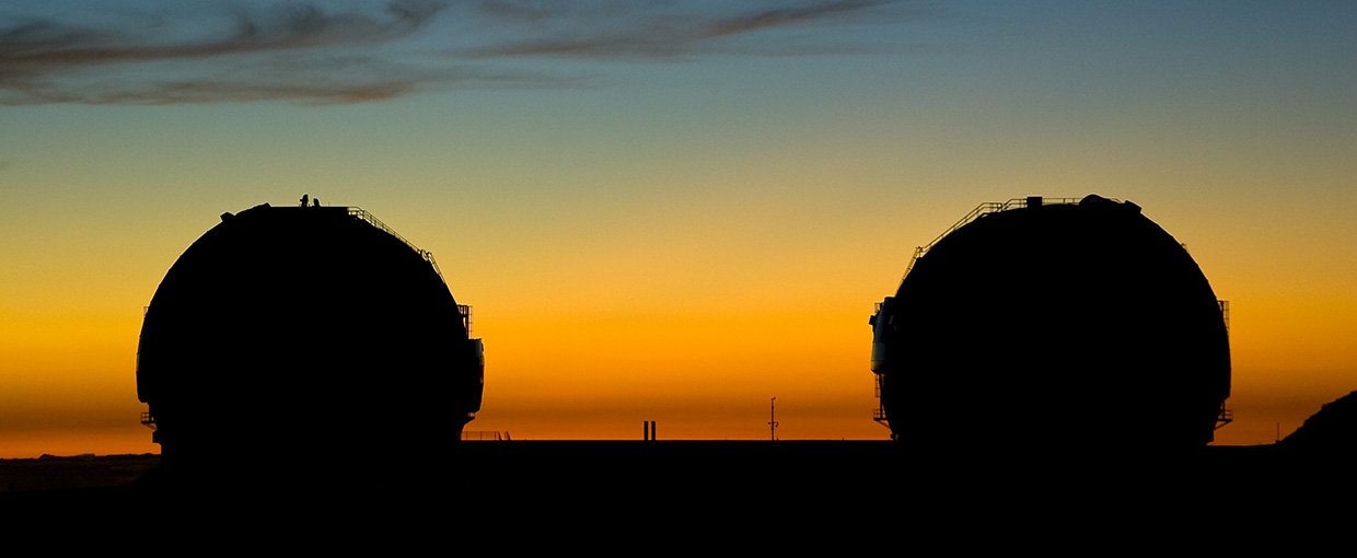 A silhouetted view of the Keck telescopes at sunset.