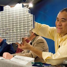 Dr. Peter Tsou, Stardust deputy principal investigator, holds a Stardust sample tray while speaking to various news media representatives during a press conference at Johnson Space Center.