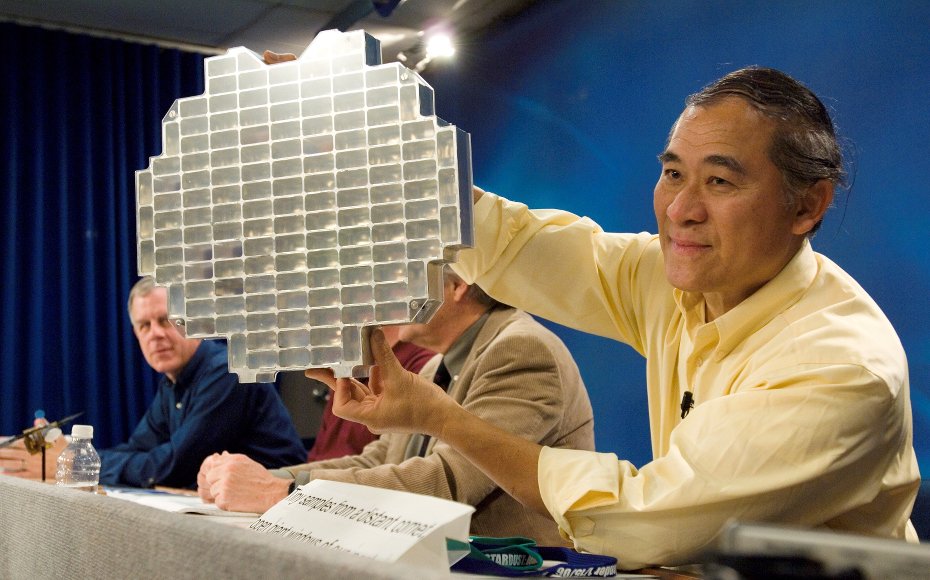 Dr. Peter Tsou, Stardust deputy principal investigator, holds a Stardust sample tray while speaking to various news media representatives during a press conference at Johnson Space Center.