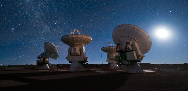 Four antennas of the Atacama Large Millimeter/submillimeter Array (ALMA) gaze up at the star-filled night sky.
